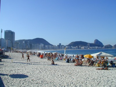 [ Pl Copacabana, situovna na jihu Ria de Janeira pitahuje mnoho nvtvnk. Vpravo na horizontu je vidt Homole cukru. ]